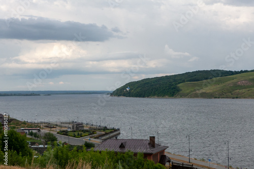 Overcast skies loom as calm waters reflect the enchanting landscape of Sviyazhsk, inviting peaceful exploration. photo