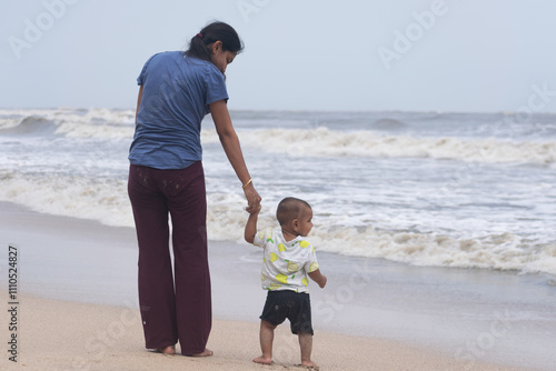 Single mother with baby at beach. Sea trip picnic insurance future NPS Vatsalya life education savings family love care upbringing independent freedom working homemaker job playing cuddling 