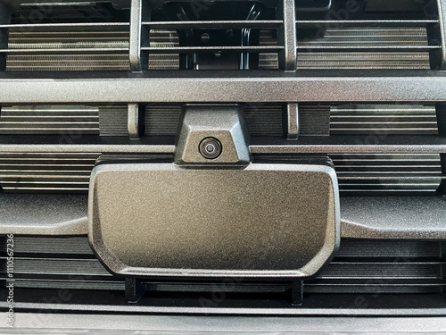 The image shows a closeup of a cars front, highlighting details like the stylish grille, sophisticated lights, unique hood design, and a camera for improved functionality and aesthetics photo