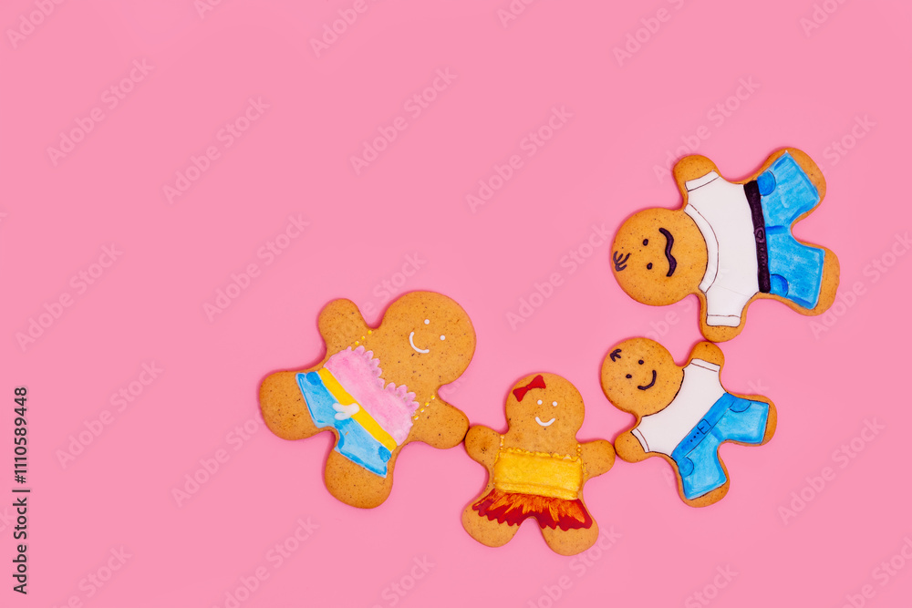 Obraz premium Top view of a family of gingerbread men on a pink background. Ginger cookies. Food concept. Family Day.