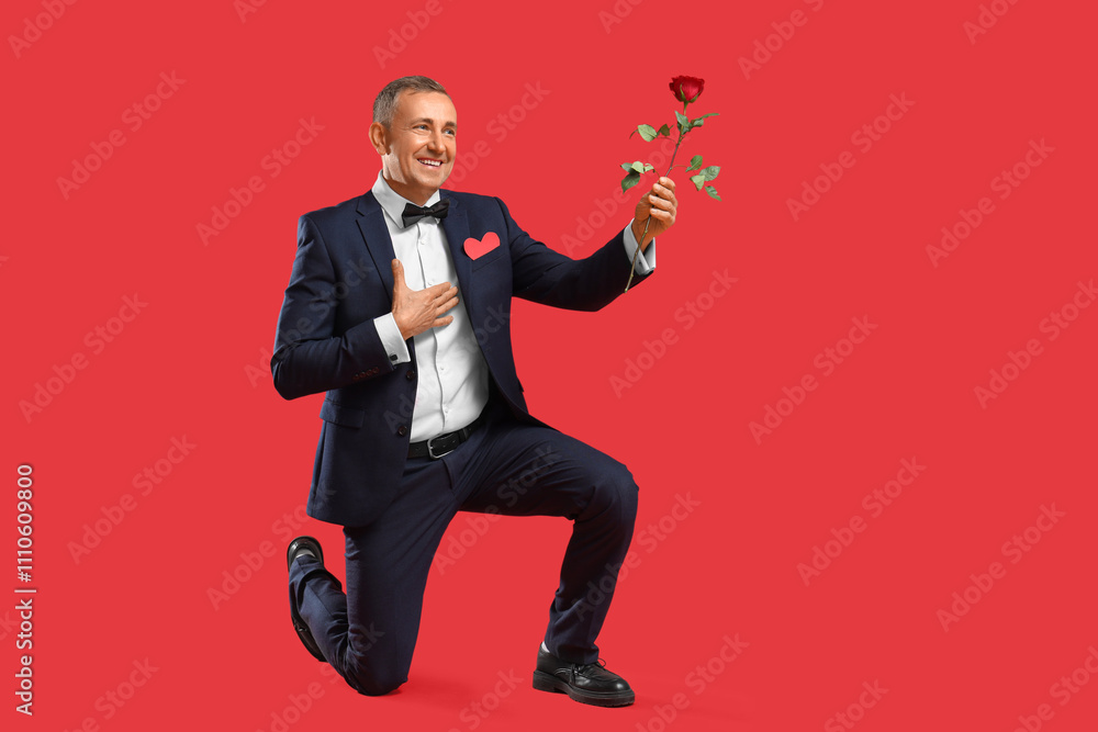 Happy mature man with rose flower on red background. Valentine's day celebration Happy mature man with rose flower on red background. Valentine's day celebration