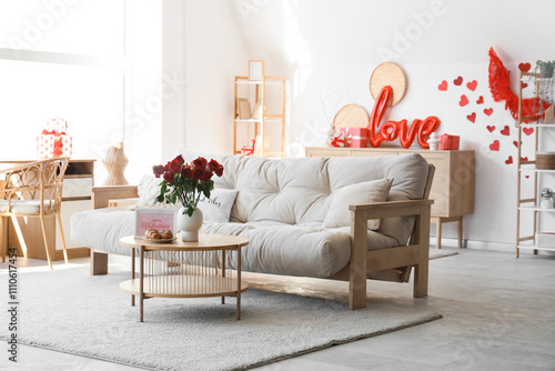Interior of light living room decorated for Valentine's Day with sofa, table and gifts