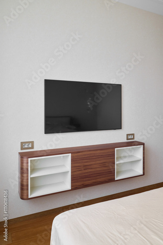 A modern bedroom designed with a wallmounted television and a stylish, sleek storage unit photo