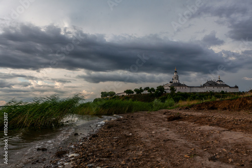 Overcast skies loom over the enchanting island of Sviyazhsk, where nature meets history along the waters edge. photo