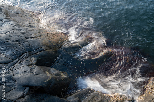 waves washing over rugged rocks under the surface. Taken with a slow shutter photo