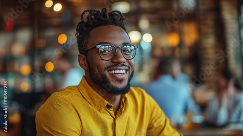 Happy Young Man Wearing Glasses Smiles in Cafe