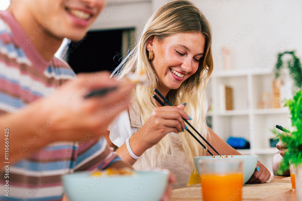 Multiethnic group of young friends meeting at home and eating poke bowls Multiethnic group of young friends meeting at home and eating poke bowls