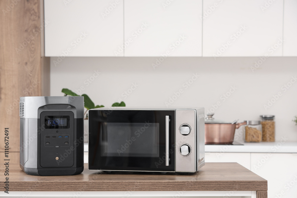 Obraz premium Portable power station with microwave oven on table in kitchen