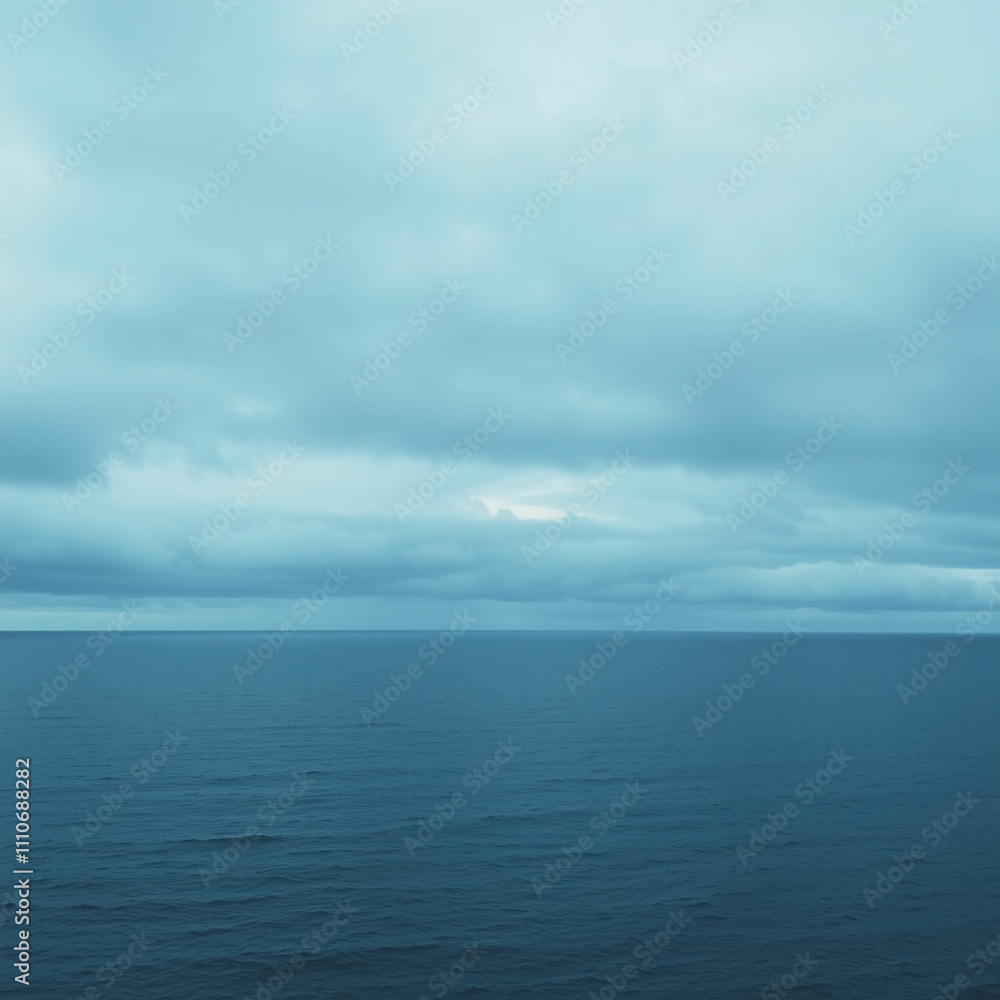 A calm blue sea with rolling waves and a distant island silhouetted against a cloudy sky. A calm blue sea with rolling waves and a distant island silhouetted against a cloudy sky.