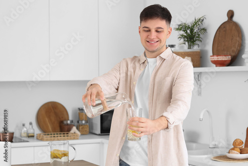 Young man pouring water int...