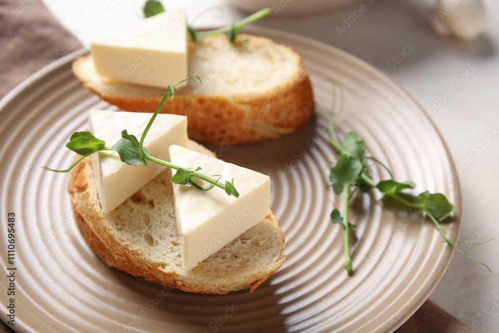 Plate with bread, triangles of tasty processed cheese and micro green on light table, closeup Plate with bread, triangles of tasty processed cheese and micro green on light table, closeup