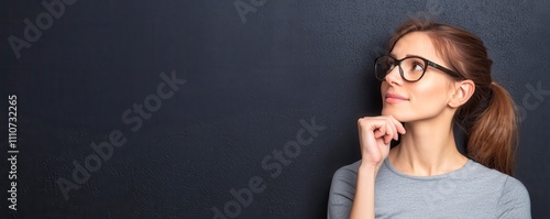 Boss woman career powerful concept. A thoughtful woman with glasses gazes upward, contemplating ideas against a dark background.