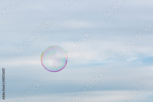 Einzelne Seifenblase am Himmel in Regenbogenfarben
