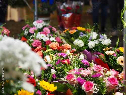 A vibrant market scene with diverse flower arrangements features roses, sunflowers, and more, highlighting the abundance and beauty of natural floral displays. photo