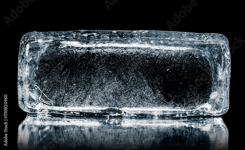 Natural textured ice block with internal cavity isolated on a black background with reflection.