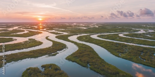 Aerial view of vibrant tidal waterways winding through lush green wetlands at sunset offering a tranquil escape in nature. photo