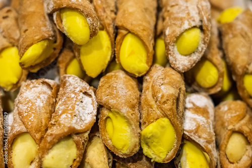 Cannoli, Sicilian pastry consisting of a tube shaped shell of fried pastry dough, filled with a sweet, creamy filling containing ricotta cheese. Italian cannolo and Sicilian cannolu. photo