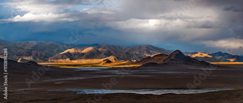 Tajikistan. A picturesque sunset in the valley of the mountainous desert lake Bulunkul on the northeastern section of the Pamir tract. photo