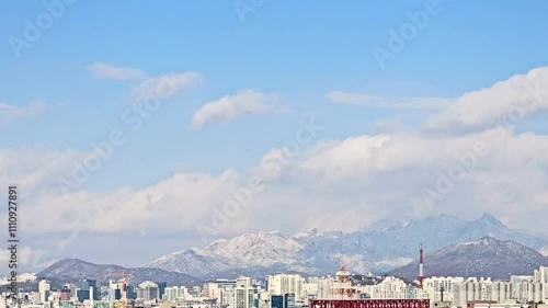 time lapse, Panoramic Snowy winter landscape background, with snow-dusted Bukak and other mountains providing a majestic backdrop to an urban skyline, in Seoul, South Korea photo