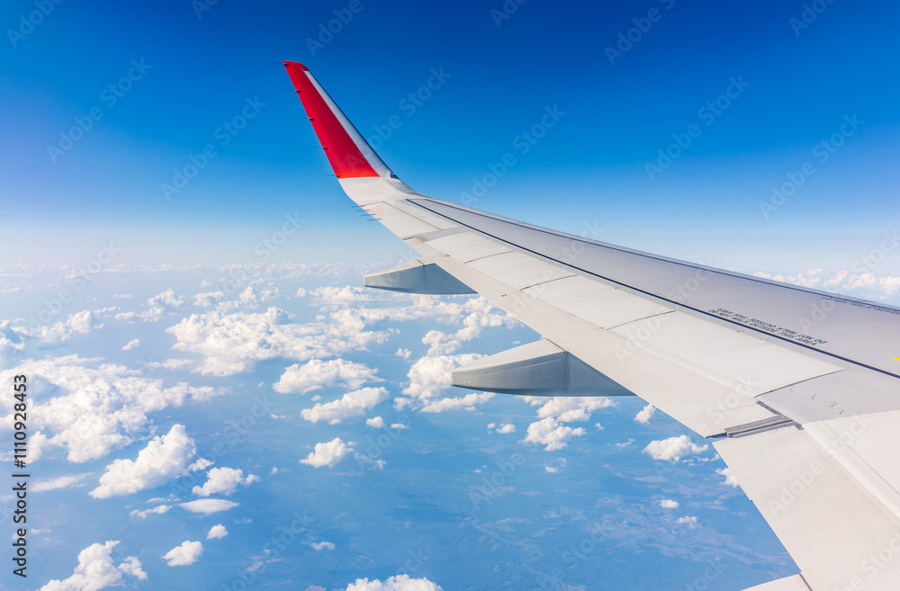 View from the airplane window at a beautiful cloudy sky and the airplane wing View from the airplane window at a beautiful cloudy sky and the airplane wing