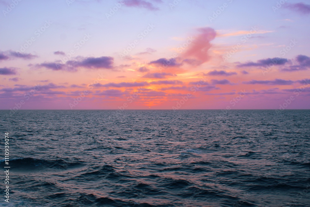 Fototapeta premium Serene Sunset Over Calm Ocean Waves with Colorful Sky 