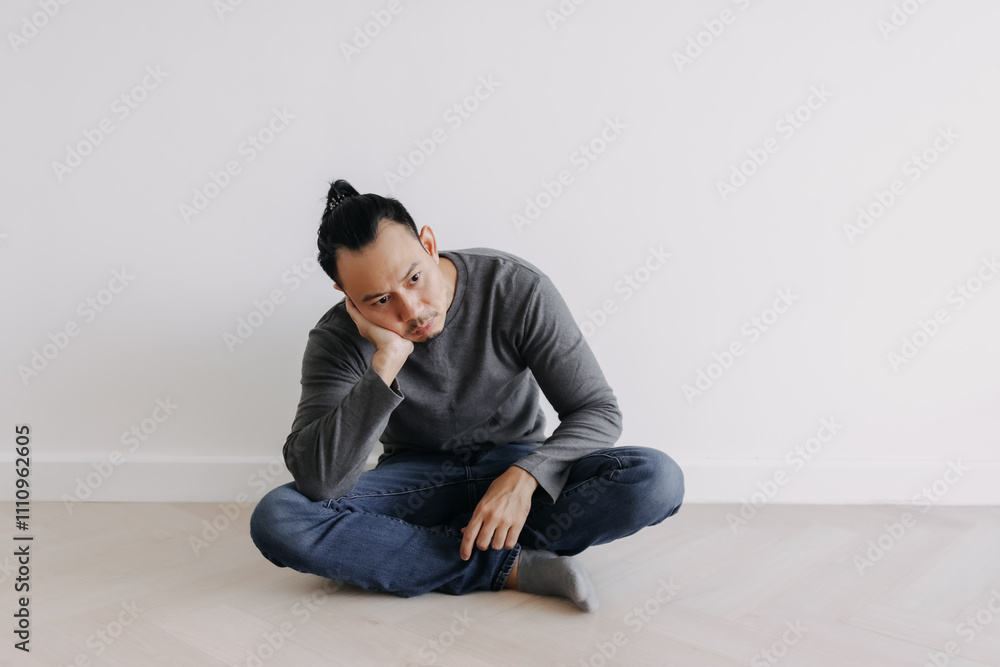 Lonely Freelance creative Asian man sitting alone in empty white room. Lonely Freelance creative Asian man sitting alone in empty white room.