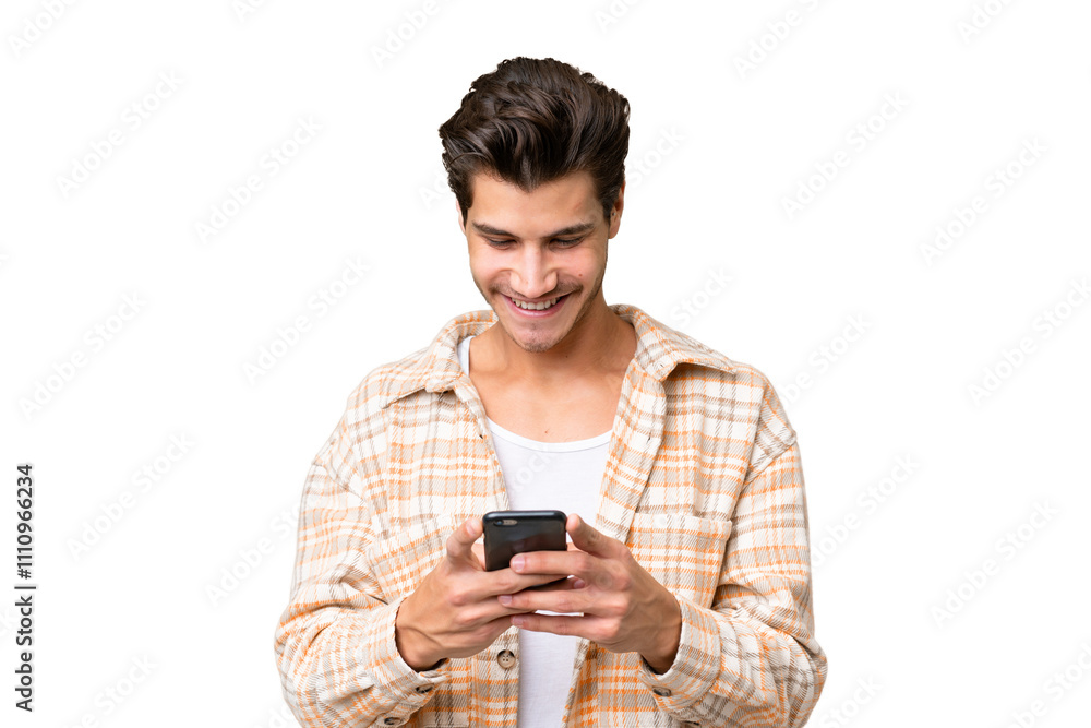 Young handsome caucasian man over isolated background sending a message with the mobile Young handsome caucasian man over isolated background sending a message with the mobile