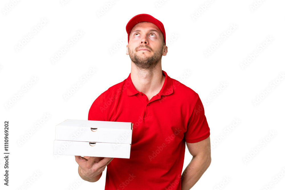Pizza delivery man with work uniform picking up pizza boxes over isolated chroma key background and looking up Pizza delivery man with work uniform picking up pizza boxes over isolated chroma key background and looking up