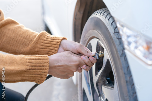Inflating car tires with both hands Car tire inflation service Check the maintenance and safety of your wheels and inflate them at the gas station. Safe driving concept.