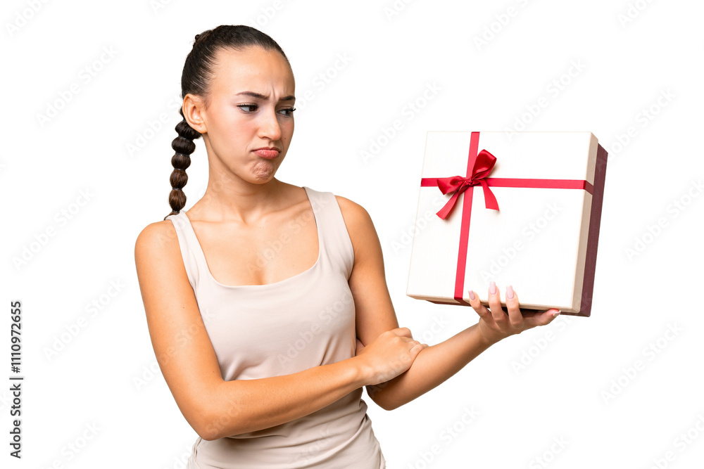 Young Arab woman holding a gift over isolated background with sad expression Young Arab woman holding a gift over isolated background with sad expression