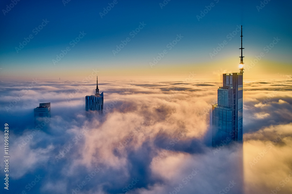 Beautiful panoramic fabulous, mesmerizing, unreal, aerial drone view of skyscrapers sticking out of low fog at sunrise, Warsaw, Poland, EU. VARSO - the tallest skyscraper in EU.
