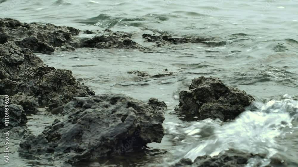 Close-up of waves hitting coastal rocks. Seaside waves crashing against the rocks. 4k. Close-up of waves hitting coastal rocks. Seaside waves crashing against the rocks. 4k.