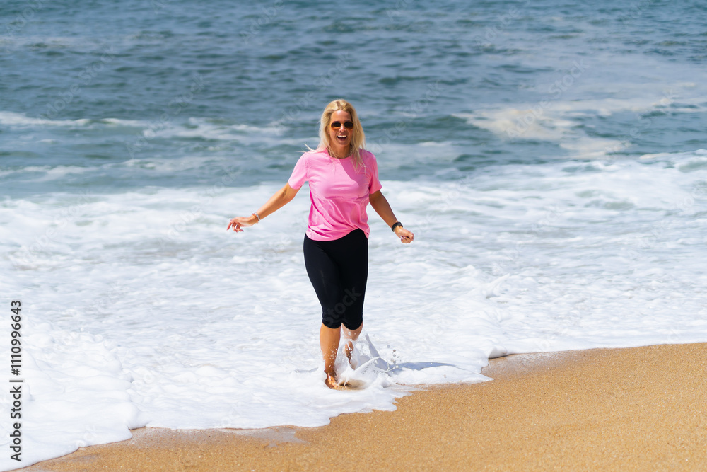 Young happy girl of European appearance on the sandy shore of the Atlantic Ocean. Young happy girl of European appearance on the sandy shore of the Atlantic Ocean.