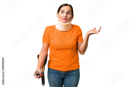 Middle-aged caucasian woman wearing neck brace over isolated background having doubts while raising hands photo