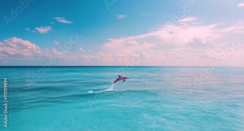 Dolphin leaps gracefully above crystal clear waters during a peaceful aquatic moment photo