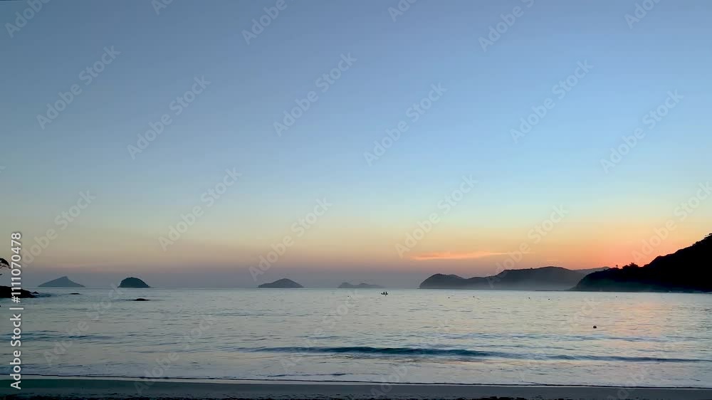 Final de tarde, dois pescadores remando. Ao fundo, Ilha Montão de Trigo, Ilha dos Gatos, Ilha das Couves e As Ilhas. Um biguá, ave pescadora típica, faz um de seus voos parabólicos característicos. Final de tarde, dois pescadores remando. Ao fundo, Ilha Montão de Trigo, Ilha dos Gatos, Ilha das Couves e As Ilhas. Um biguá, ave pescadora típica, faz um de seus voos parabólicos característicos.