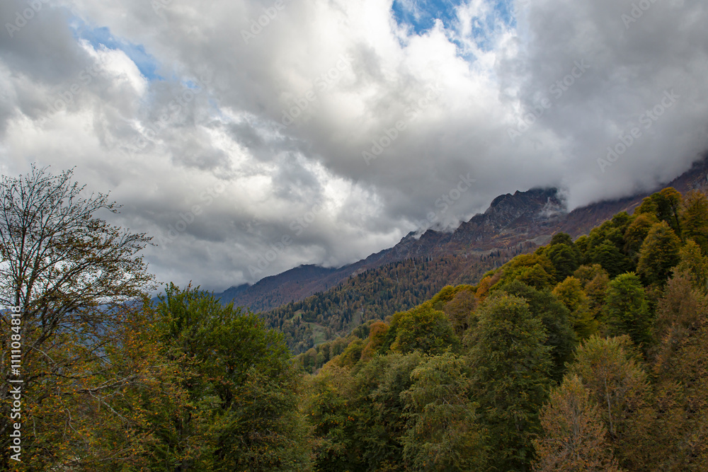 Cloudy evening at a picturesque mountain resort in autumn, heavy thunderclouds. Mountain peaks are shrouded in dark clouds. Early autumn, picturesque mountain ranges Cloudy evening at a picturesque mountain resort in autumn, heavy thunderclouds. Mountain peaks are shrouded in dark clouds. Early autumn, picturesque mountain ranges