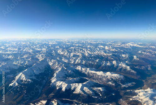 Aerial landscape of the Alps in Europe during winter season with fresh snow. Amazing view from the airplane window