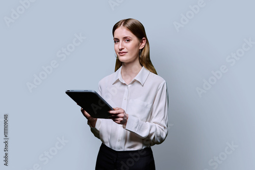 Teenager student girl with digital tablet on grey studio background