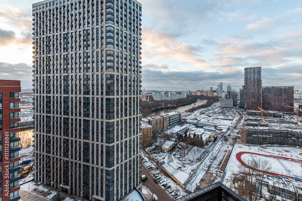 Obraz premium New residential area under construction Khoroshyovo Mnyovniki and Filevsky Park with high-rise buildings, near the Moscow River. Old residential buildings are being demolished. Winter, snow, overcast.