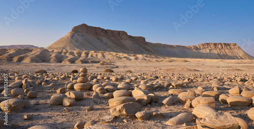 Mount Tzin or Har Zin in Negev Desert. The large field full of medium sized rounded stones called Potato Field, in foreground. Unique landscape of the mount - sloped sides and a top like flat table photo