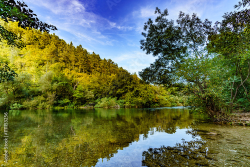 Beautiful view of a calm river hidden among the trees