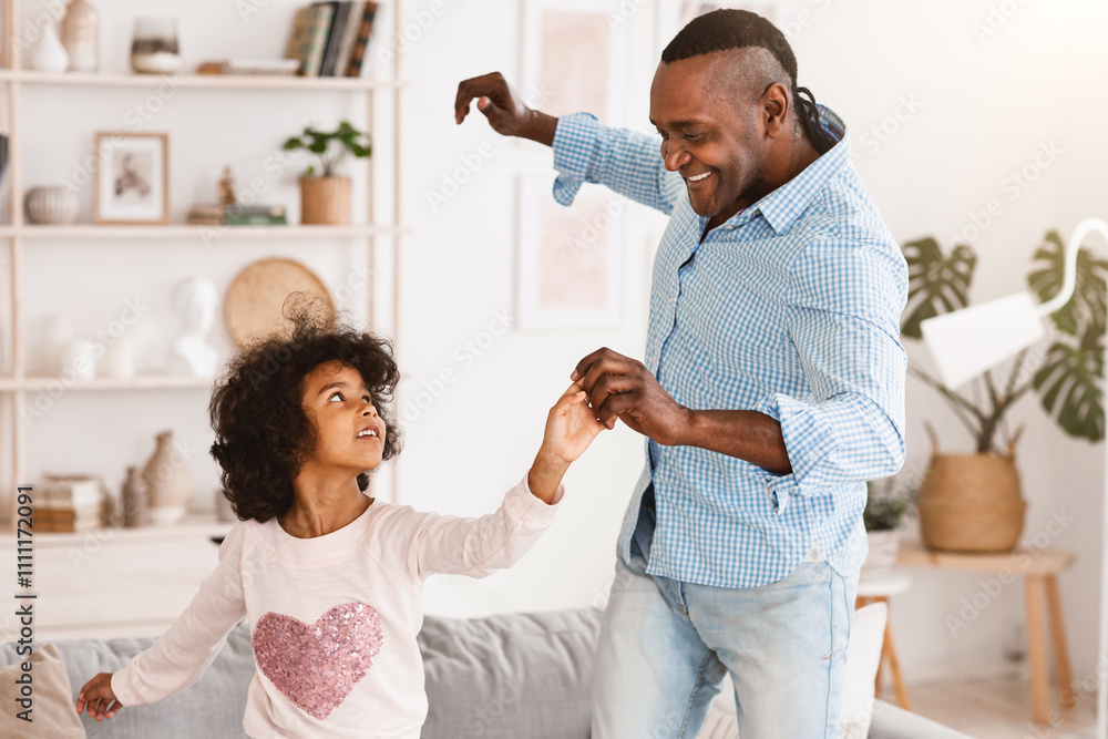 Stay home, have fun. African American granddad dancing with his little granddaughter in light room Stay home, have fun. African American granddad dancing with his little granddaughter in light room