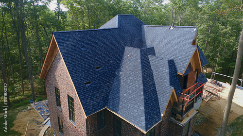A roofing contractor installing shingles on a steep roof, ensuring each shingle is properly aligned and securely fastened to prevent leaks.