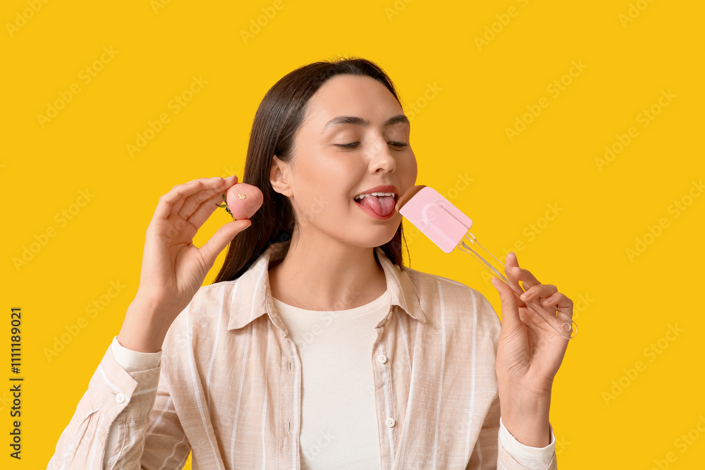 Beautiful young woman with chocolate covered strawberries and spatula on yellow background Beautiful young woman with chocolate covered strawberries and spatula on yellow background