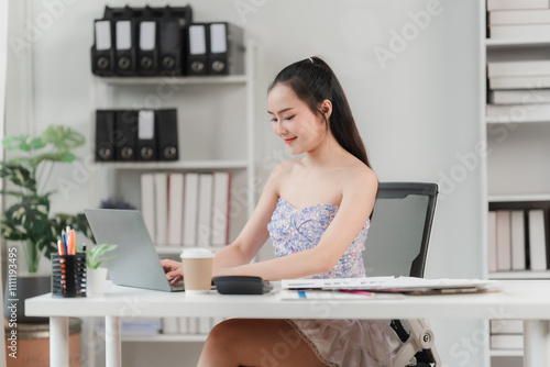 Focused and Efficient: Young businesswoman in a stylish outfit, working diligently on her laptop at her clean and organized desk, a picture of modern professional productivity. 