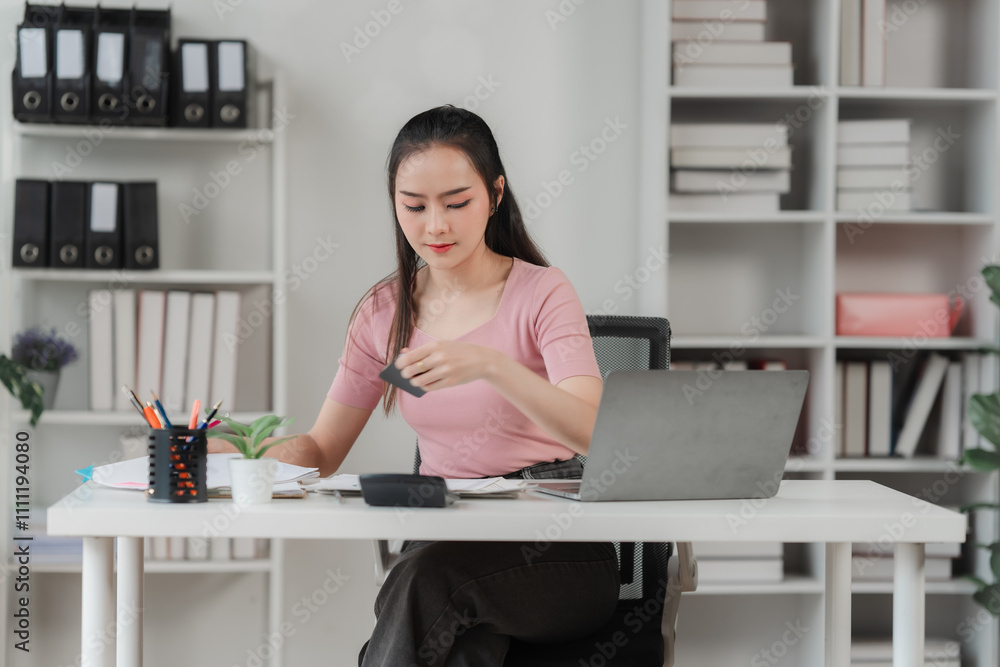 Focused and Determined: A young woman meticulously analyzes data on her laptop in a modern office setting, showcasing her dedication and commitment to her work. Focused and Determined: A young woman meticulously analyzes data on her laptop in a modern office setting, showcasing her dedication and commitment to her work.