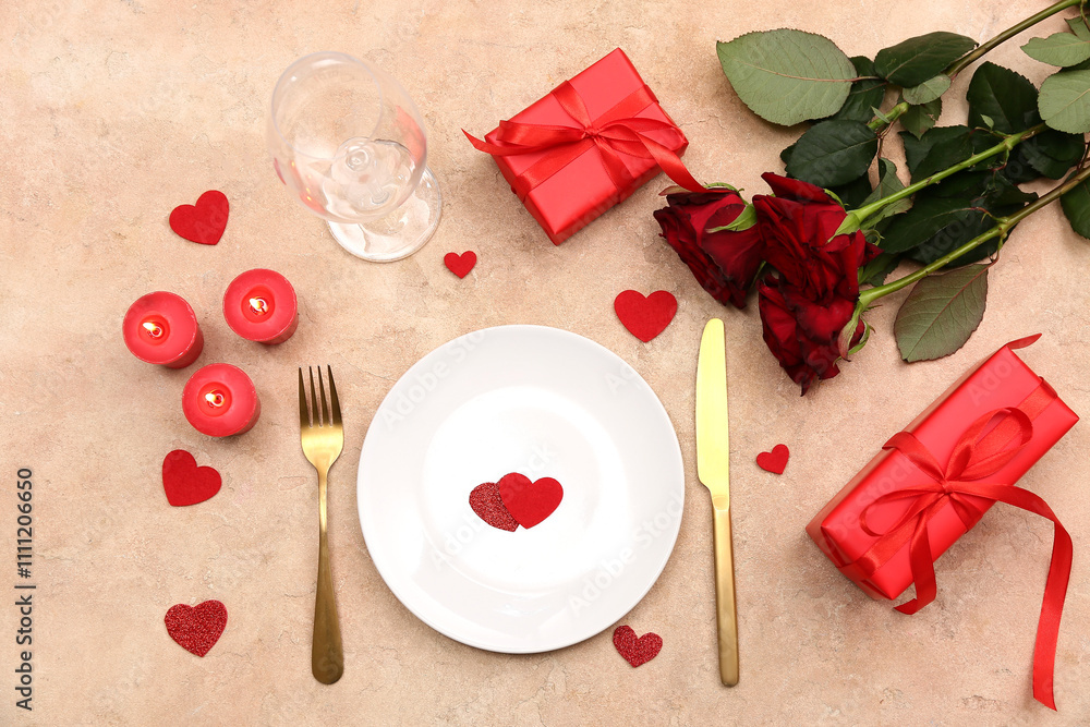 Table setting with candles, gift boxes, rose flowers and decorative hearts for Valentine's Day celebration on beige grunge background Table setting with candles, gift boxes, rose flowers and decorative hearts for Valentine's Day celebration on beige grunge background