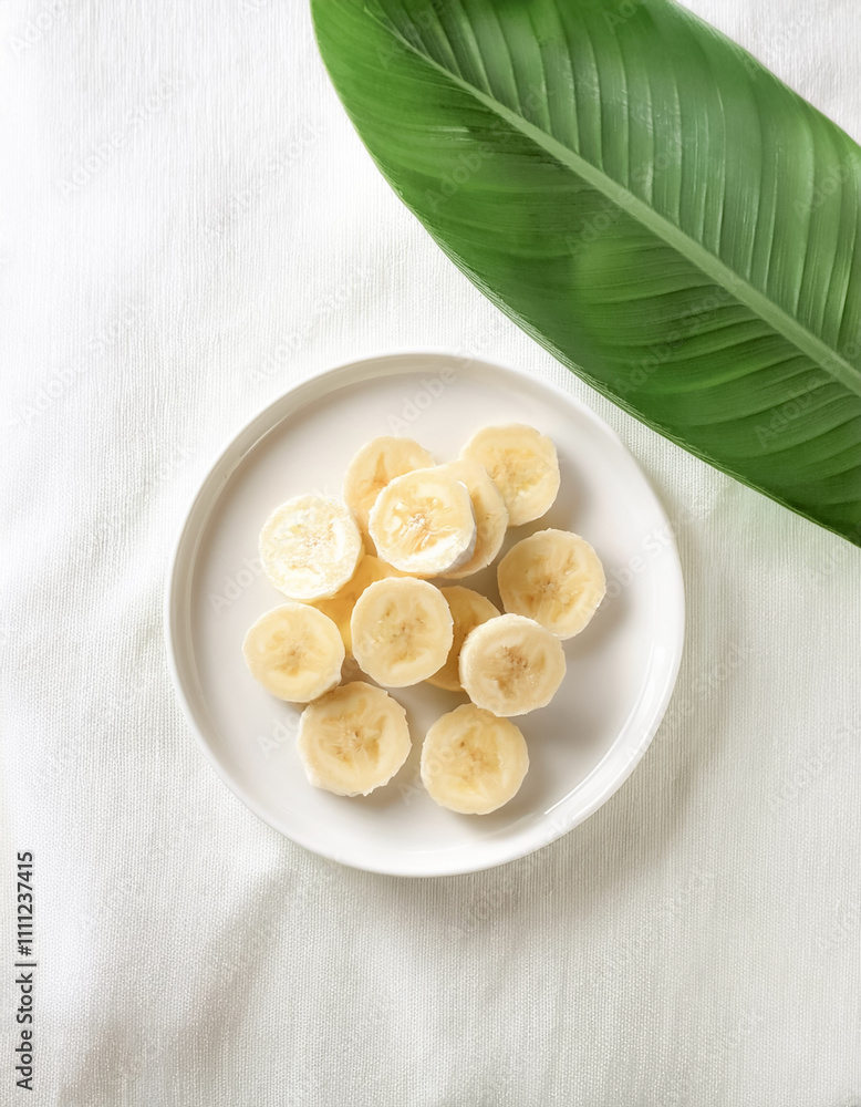 small slices of Banana on a clean white plate on white small slices of Banana on a clean white plate on white