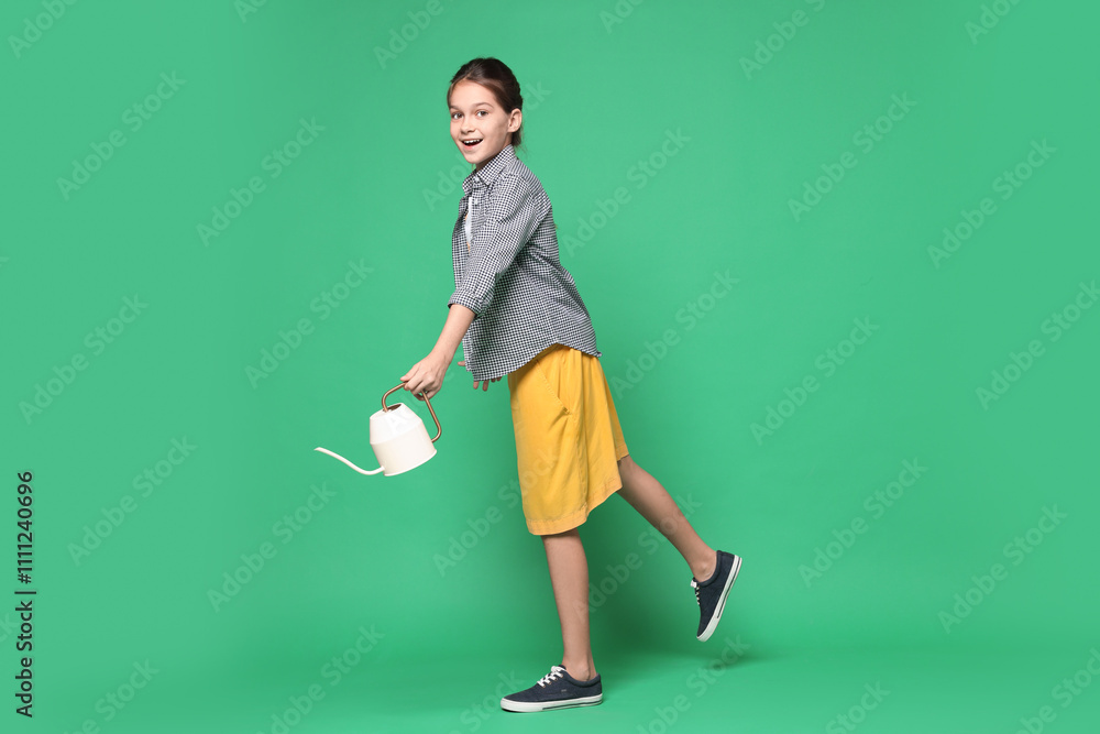 Girl with watering can pretending to be gardener on green background. Dreaming of future profession